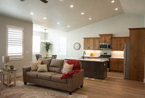 Living area featuring recessed lighting, light wood-type flooring, high vaulted ceiling, and a ceiling fan