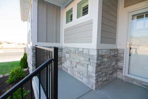 Entrance to property with stone siding, covered porch, and board and batten siding