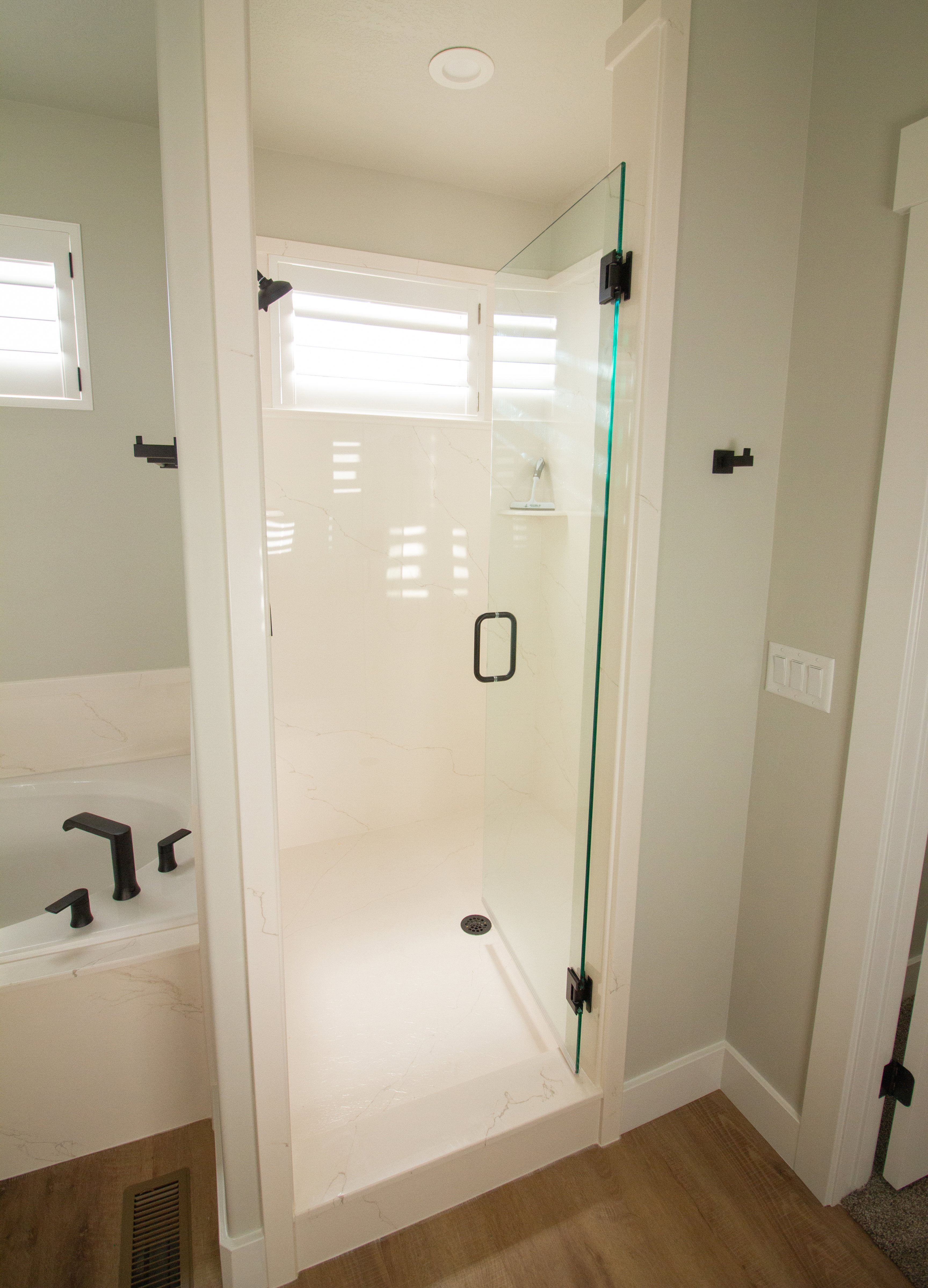 Master bathroom with a shower stall, wood finished floors, and a garden tub