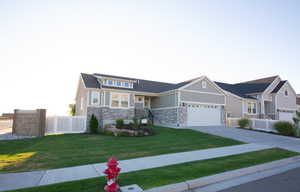 Craftsman-style home featuring stone siding, concrete driveway, and board and batten siding