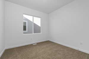 Spare room featuring carpet floors and baseboards