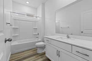 Full bath featuring vanity, bathing tub / shower combination, and dark wood finished floors