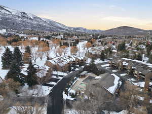 Snowy aerial view with a mountain view and a residential view
