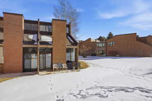 Snow covered house featuring a patio area