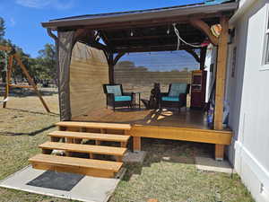 Wooden terrace featuring a playground and a gazebo