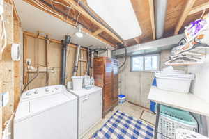 Laundry area with concrete floors and washing machine and clothes dryer