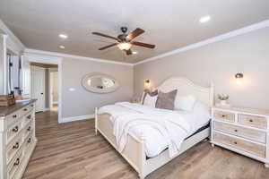Bedroom featuring light wood-style flooring, ceiling fan, and ornamental molding