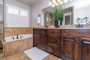 Bathroom featuring double vanity, a garden tub, and a shower stall