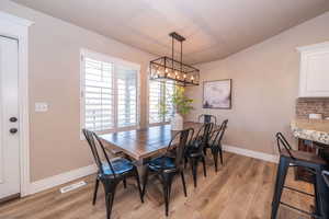 Dining room featuring light wood finished floors and a chandelier