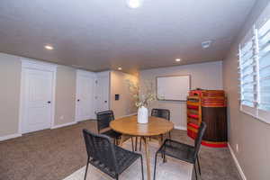 Dining room with recessed lighting, carpet, and a textured ceiling