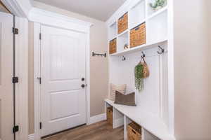 Mudroom with dark wood-style floors and baseboards