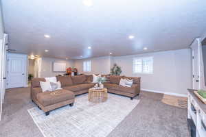 Carpeted living area featuring recessed lighting and a textured ceiling