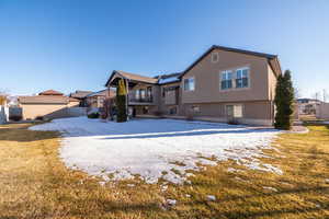 Snow covered back of property featuring stucco siding, a balcony, and a patio