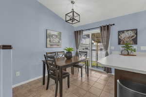 Dining room featuring lofted ceiling and light tile patterned flooring
