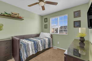 Bedroom with light carpet and a ceiling fan