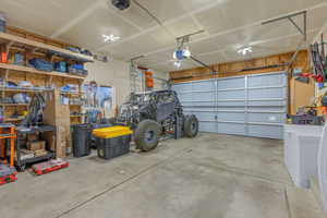 2 car heated garage with white fridge and a garage door opener