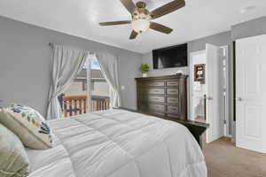 Bedroom with access to outside, light carpet, ceiling fan, and ensuite bathroom