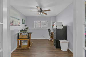 Office space with dark wood-style flooring and a ceiling fan