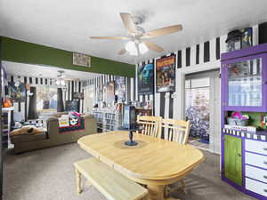 Carpeted dining room with ceiling fan