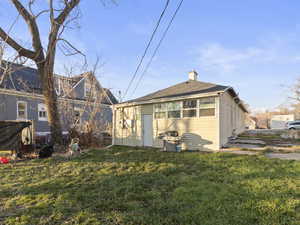 Back of house with a lawn and a chimney