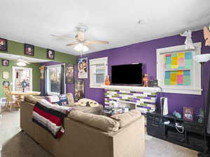 Carpeted living room with ceiling fan