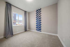 Spare room featuring light carpet and a textured ceiling