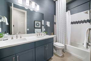 Full bath featuring double vanity and shower / tub combo