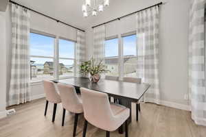 Dining area with light wood-type flooring, lofted ceiling, and hanging lights