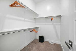 Walk in closet with dark carpet