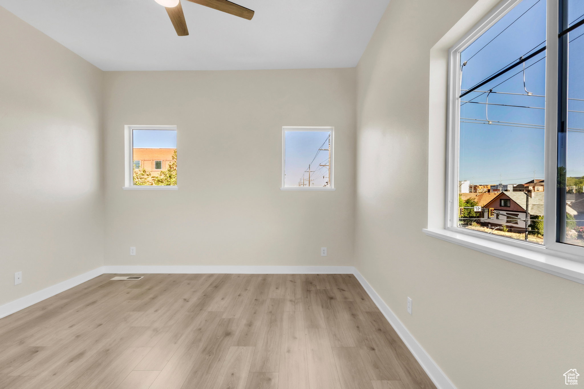 Unfurnished room with light wood-type flooring and a ceiling fan