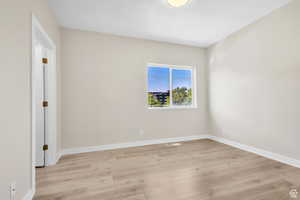 Spare room with light wood-style flooring and baseboards