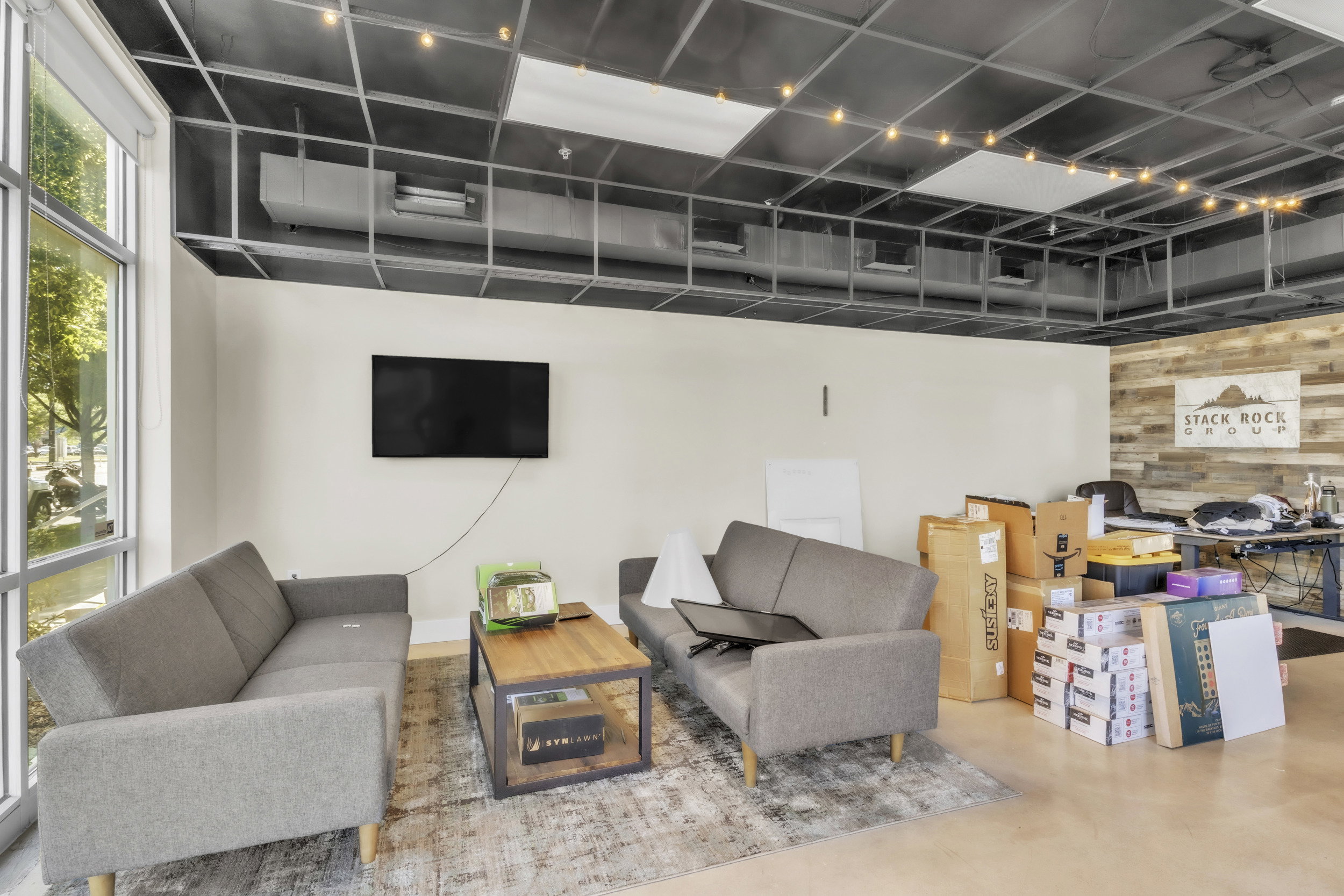 Living room featuring wood walls, finished concrete flooring, and an accent wall