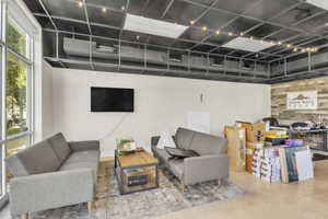 Living room featuring wood walls, finished concrete flooring, and an accent wall