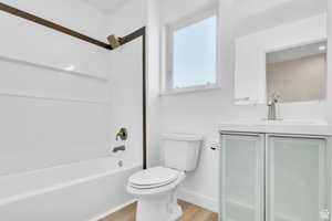 Bathroom featuring shower / bath combination, vanity, and light wood finished floors