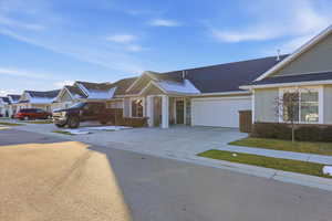 Single story home featuring concrete driveway, a garage, roof with shingles, a residential view, and board and batten siding