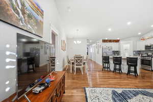 Living area featuring light wood finished floors, recessed lighting, and a chandelier