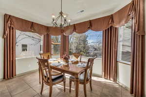 Dining area featuring a chandelier and light tile patterned flooring