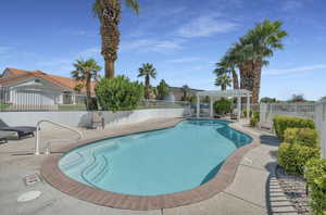 Community pool with a pergola and a patio area