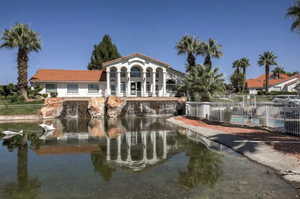 Back of house featuring a tiled roof, a water view, and stucco siding