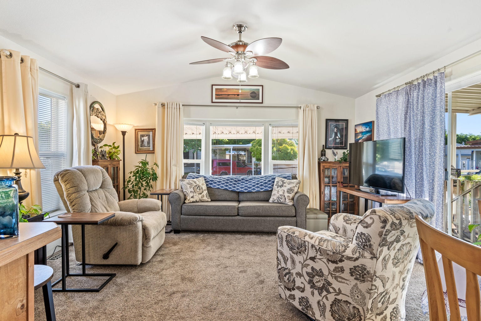Living room with vaulted ceiling, carpet floors, and plenty of natural light