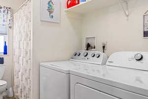 Laundry area featuring a textured wall and washing machine and dryer