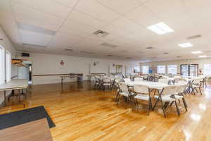 Dining space with a paneled ceiling and light wood-type flooring