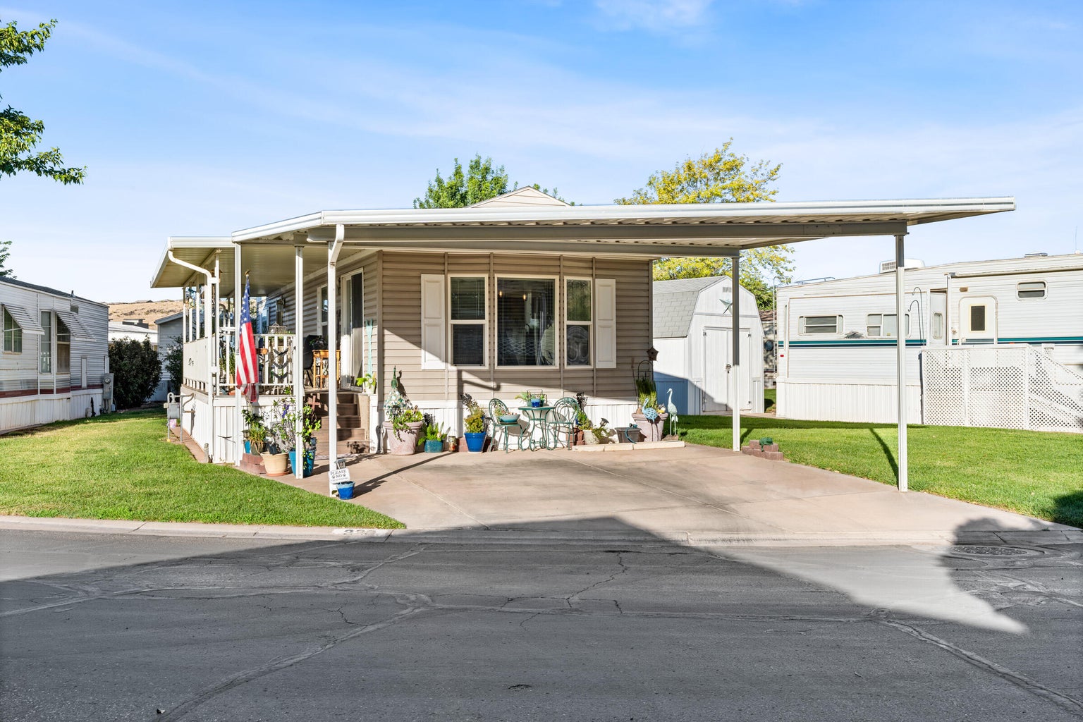 Manufactured / mobile home with a front lawn and a storage shed