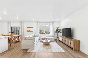 Living room with light wood-type flooring and recessed lighting