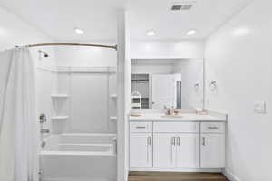 Full bath featuring shower / bath combination with curtain, vanity, and dark wood-style flooring