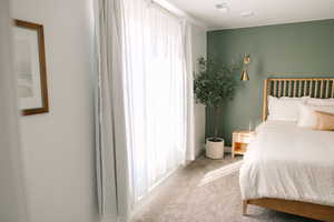 Bedroom featuring light carpet and baseboards