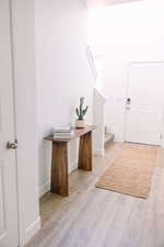Foyer featuring light wood-style flooring and stairs