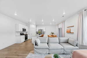 Living room with light wood-style floors and recessed lighting