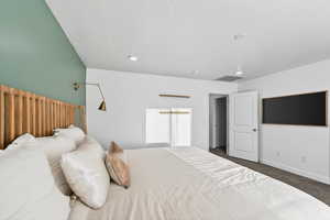 Bedroom with dark carpet and a textured ceiling