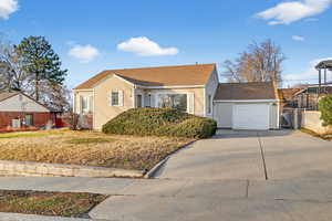 Bungalow with driveway, roof with shingles, and a garage